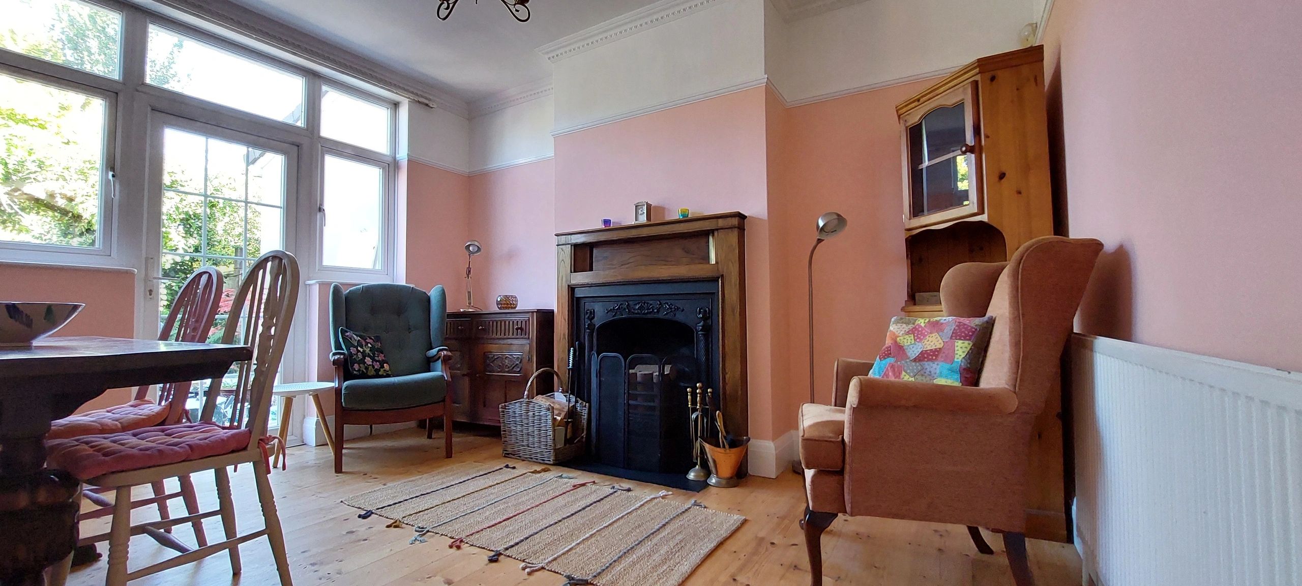 Finished period living room with warm painted walls and a traditional fireplace