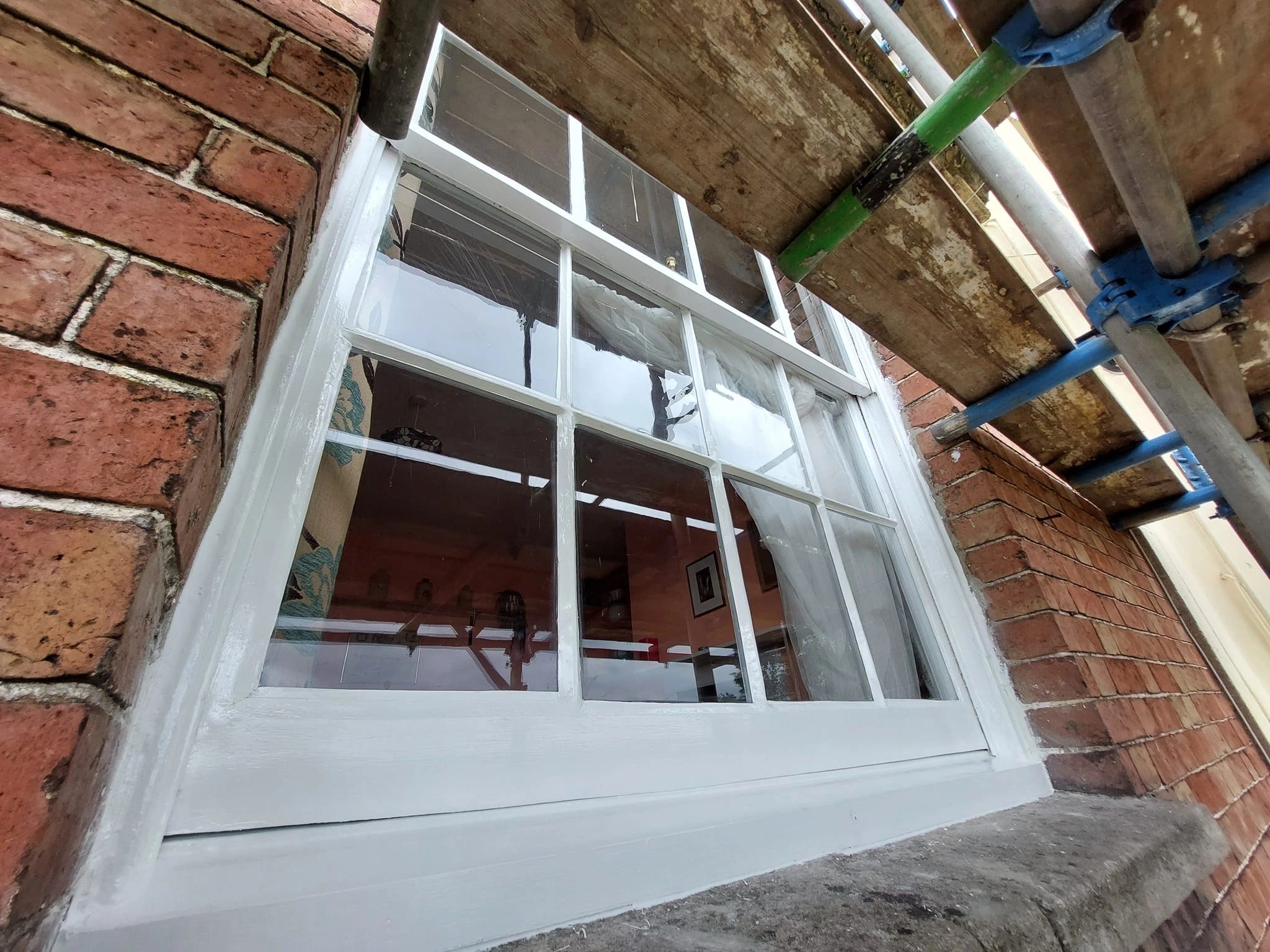 Freshly restored exterior sash window with white painted timber
