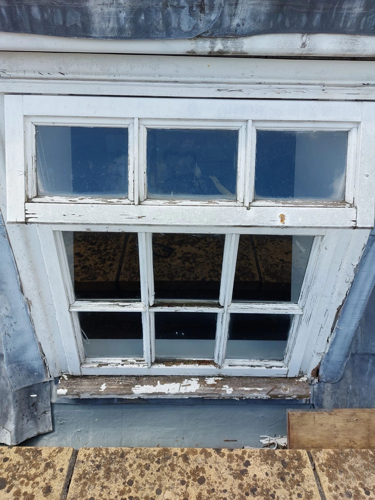 Weathered timber window before restoration with flaking and failing paint